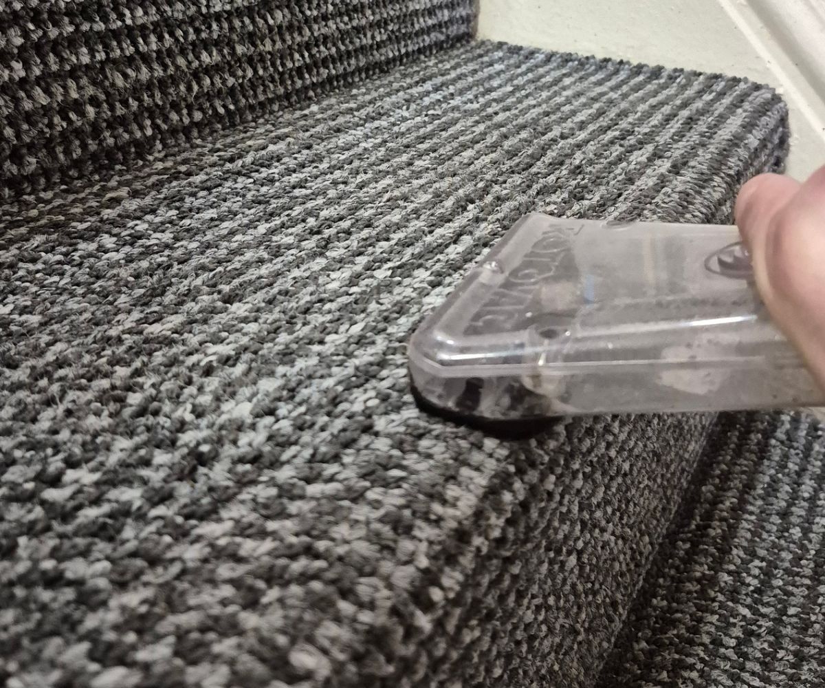 Professional hot water extraction cleaning being carried out on stair carpet removing dirt and stains